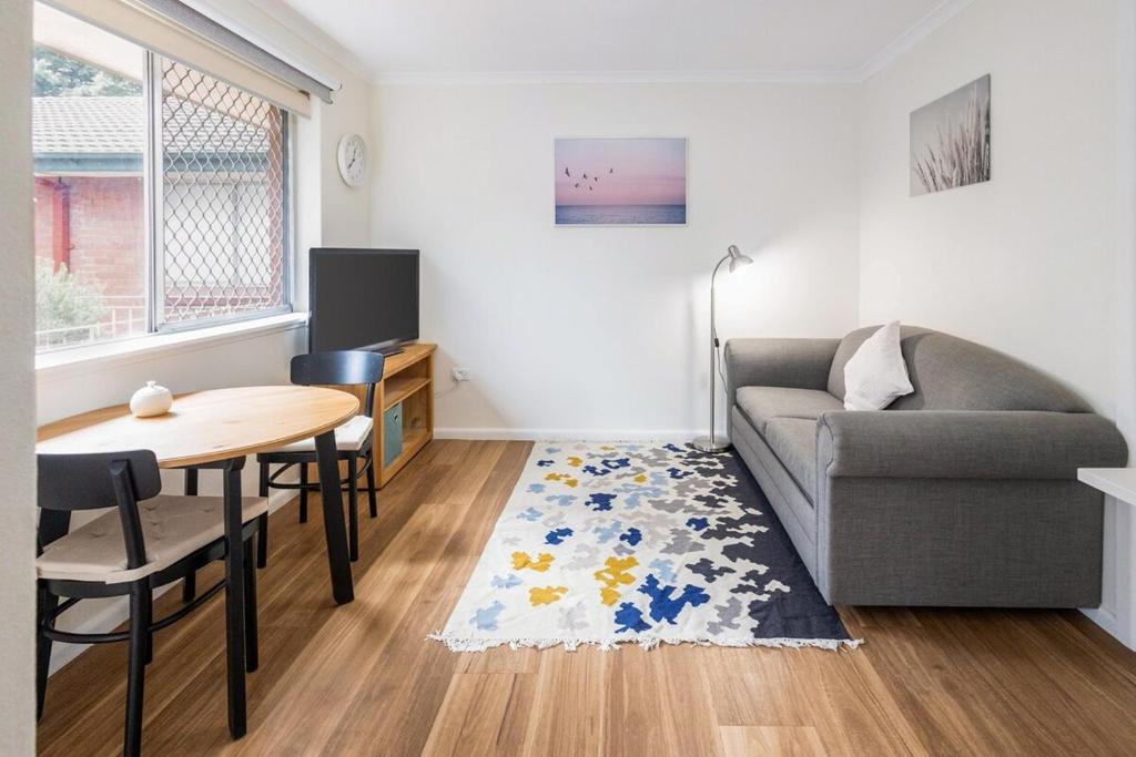 a living room with a couch and a table at Yarralumla Apartment Stay Queen Bed and Sofa Bed Free Parking in Yarralumla