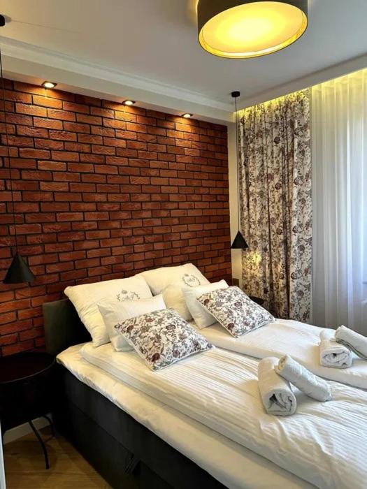 a bedroom with two beds and a brick wall at Willa Piastowska in Polanica-Zdrój