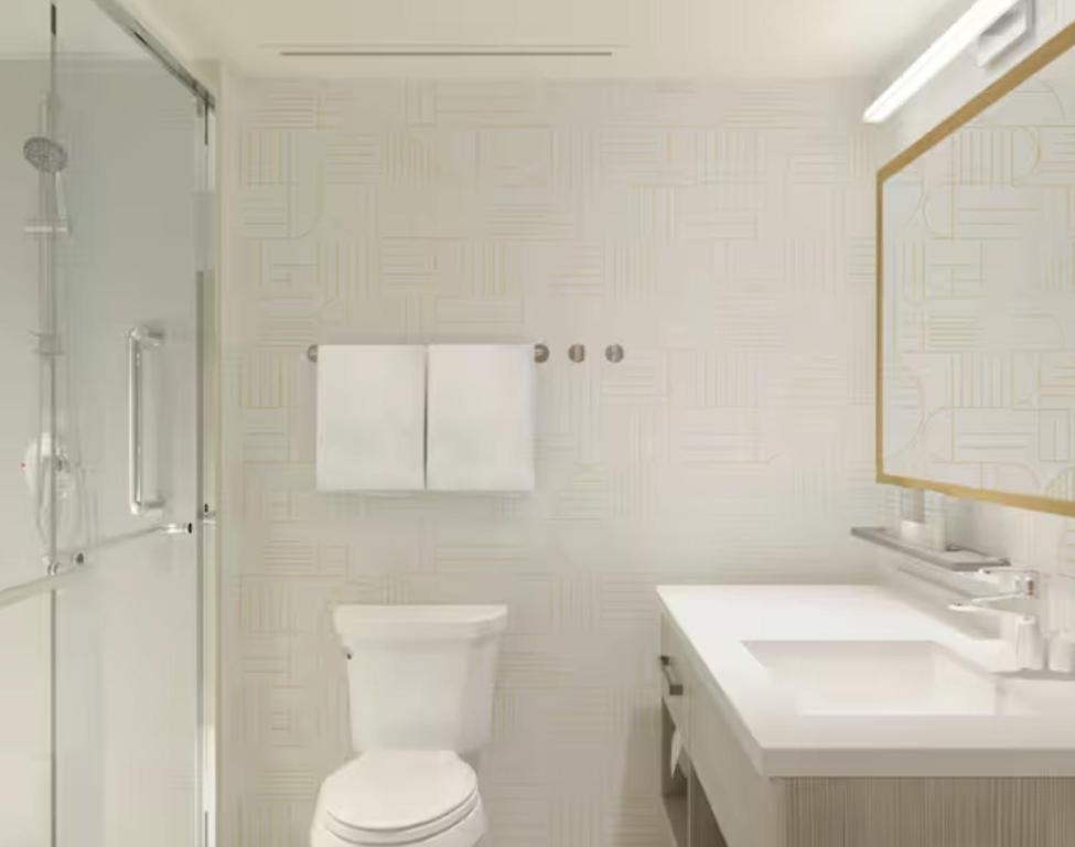 a bathroom with a toilet and a shower and a sink at Home2 Suites By Hilton Calera in Calera