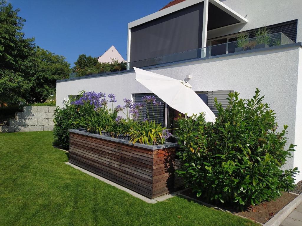 a house with a garden with an umbrella at Appartement "Am Schlosshang" mit Terrasse in Waldmünchen