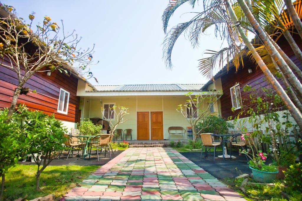 a patio with a table and chairs in front of a house at Song Youf Hostel in Zhongpu