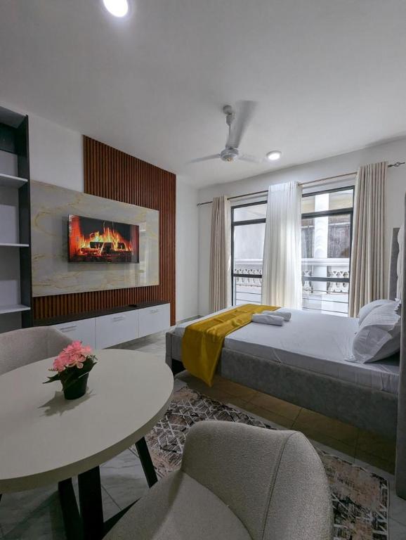 une chambre avec un lit, une table et des chaises dans l'établissement Nancy's Haven studio apartment, à Mombasa