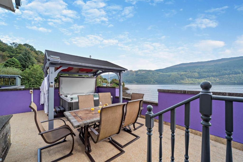 a deck of a house with a table and chairs at Jennys Bay in Carrick