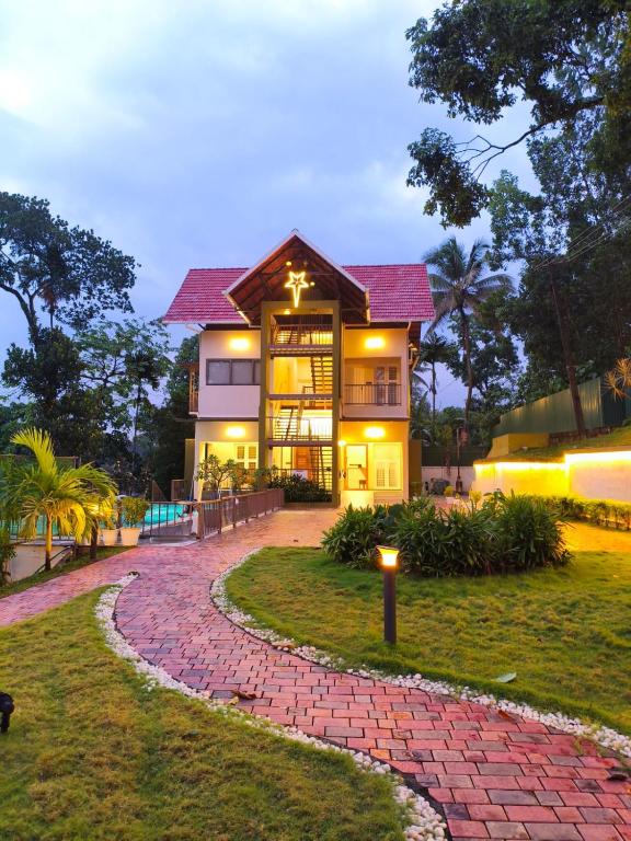 a house with a brick walkway in front of it at Foresta Thattekkadu Pool Resort in Thattakād