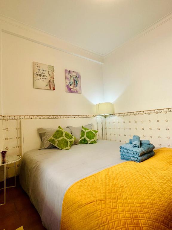 a bedroom with a bed and a yellow blanket at Casa de Sintra in Sintra