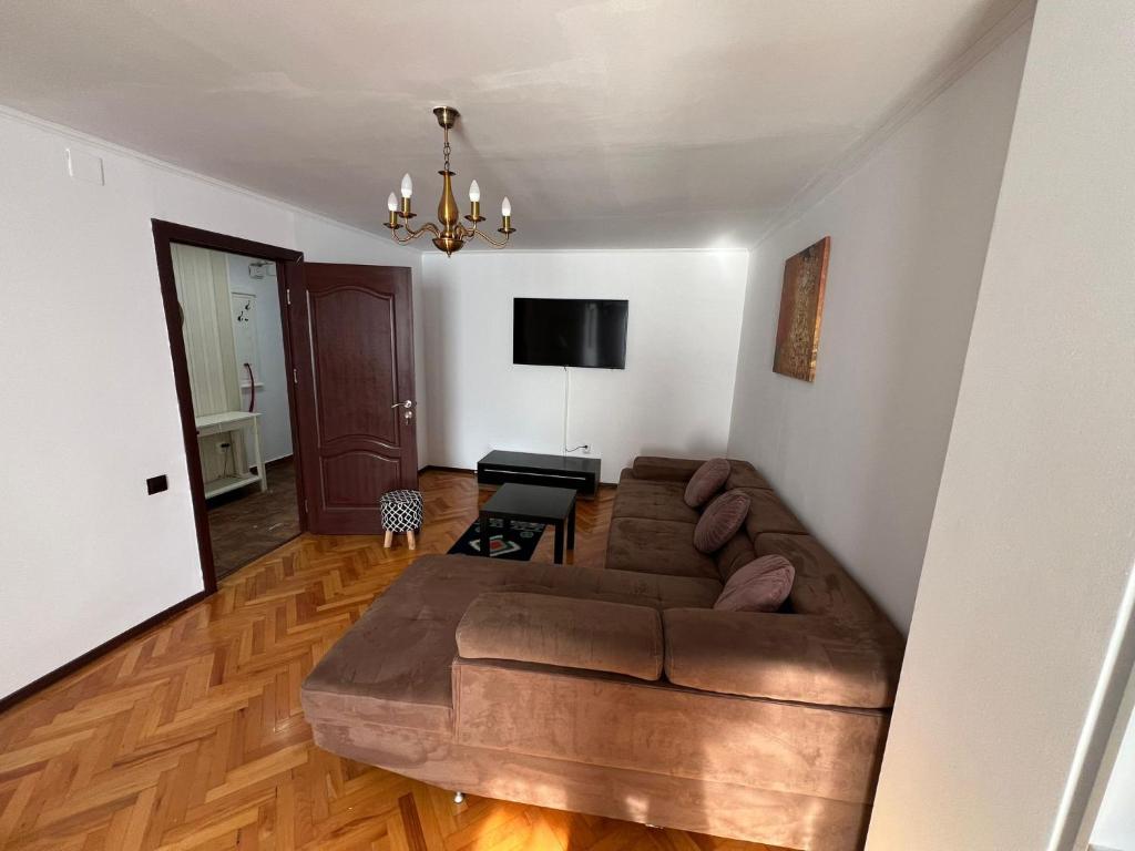 sala de estar con sofá marrón y TV en Elegant apartment, en Tulcea