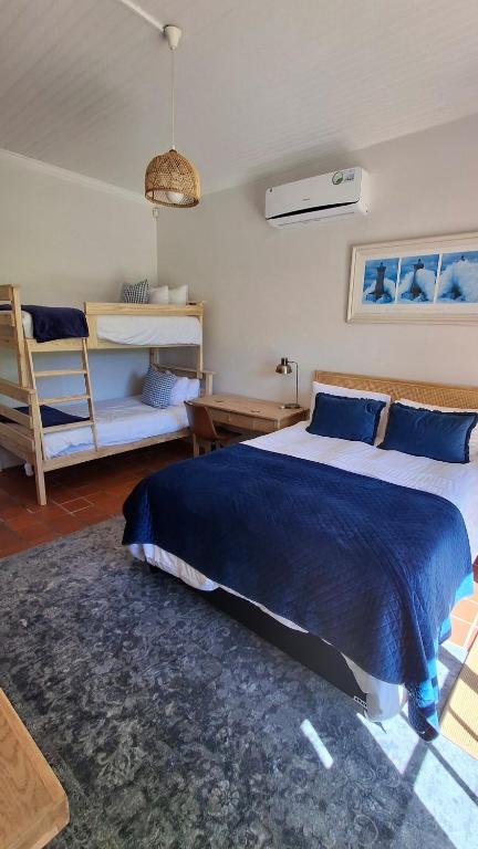 a bedroom with a large bed and a couch at La Mode Garden Cottage in Paarl