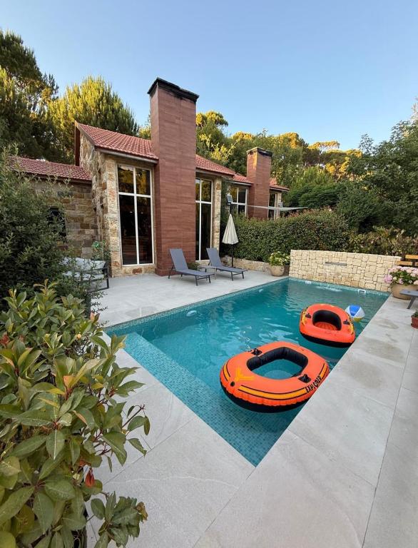two inflatable boats are sitting in a swimming pool at Mountscape in Bmahrāy