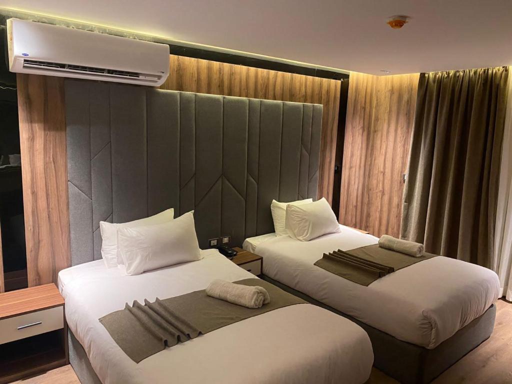 una camera d'albergo con due letti e un condizionatore d'aria di Three Pyramids View a Il Cairo