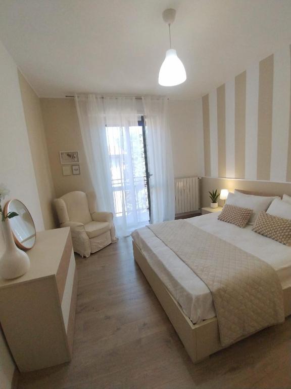 a bedroom with a large bed and a chair at Conte Durini Apartments & Rooms in Arcore