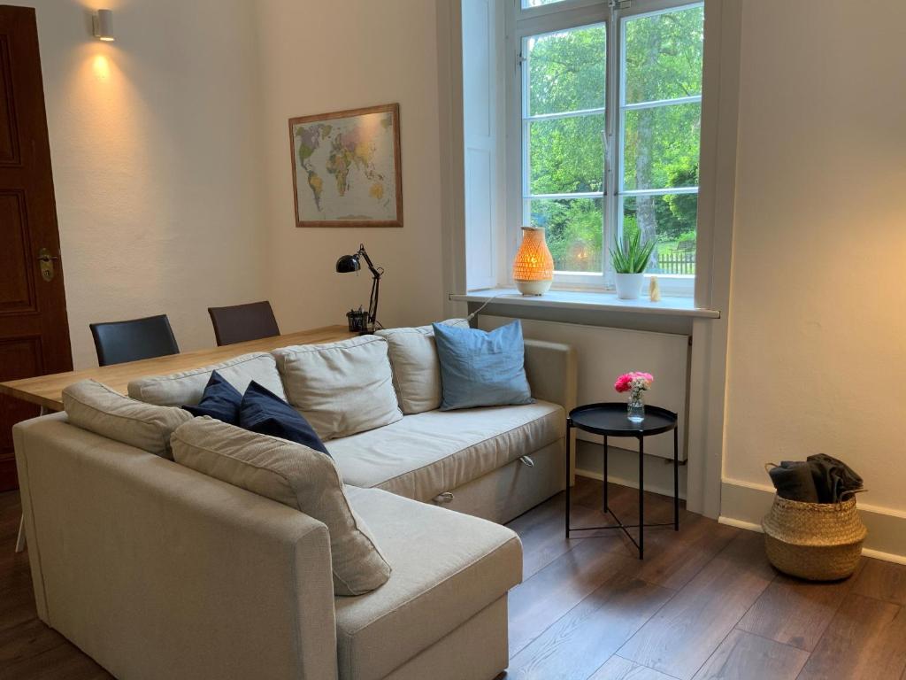 un salon avec un canapé et une fenêtre dans l'établissement Das Ministerhaus - historisches Anwesen für Gruppen und Seminare, à Bergkamen