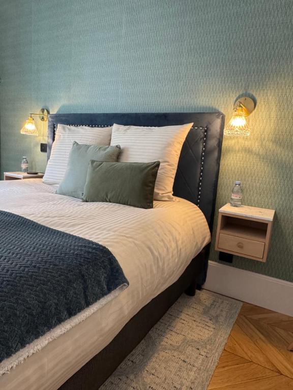 Un dormitorio con una cama grande con una pared azul. en Chambre au Jardin, en París