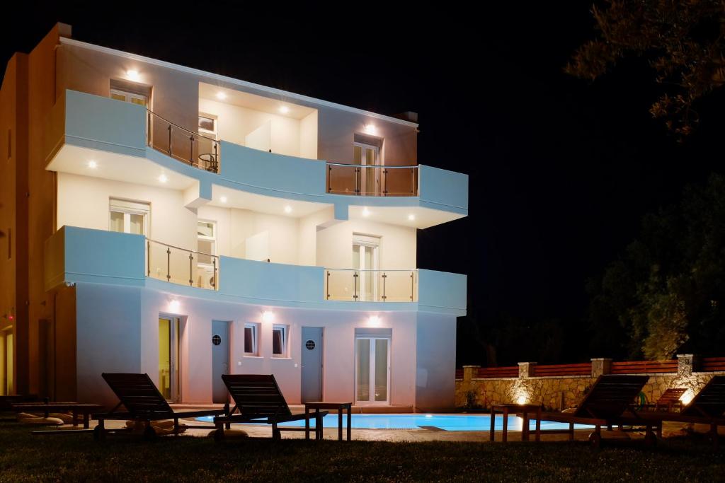 een gebouw met stoelen er 's nachts voor bij Kamares Luxury Apartments in Lefkada