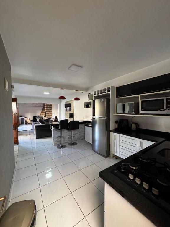 a kitchen with black and white tile floors and appliances at Casa disponível in Ibirubá