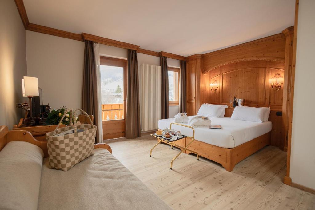 a hotel room with a bed and a couch at Gaarten Hotel Benessere Spa by Kleos Group Collection in Gallio