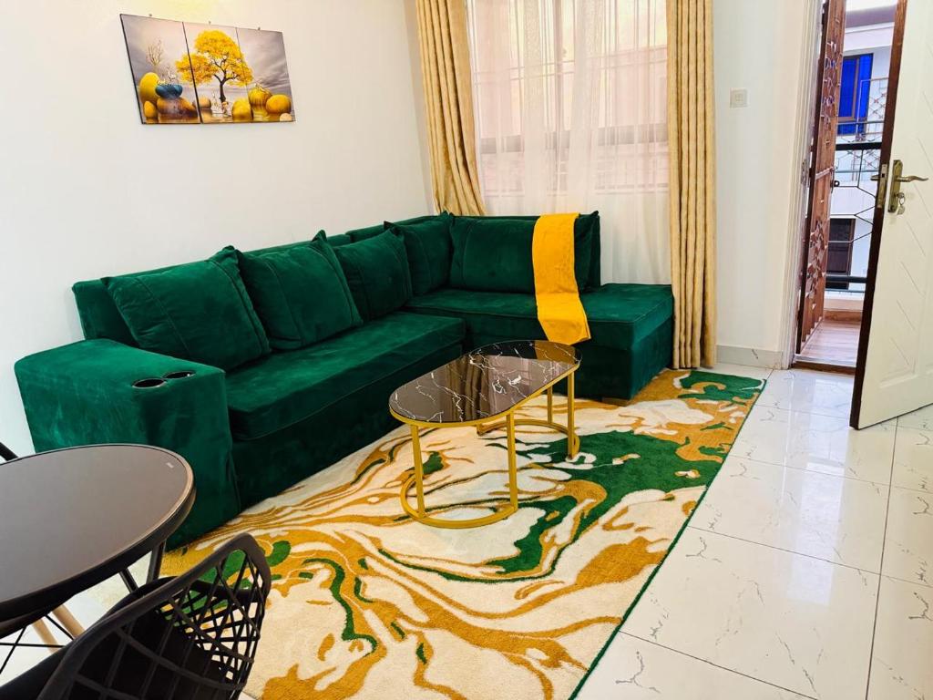 a living room with a green couch and a table at MJ Homes Mombasa - Cosy and lavish 2 bedroom apartment master ensuite unit in Mombasa