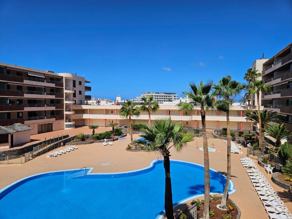 a view of a resort with a swimming pool and palm trees at Summer breeze in Puerto de Santiago