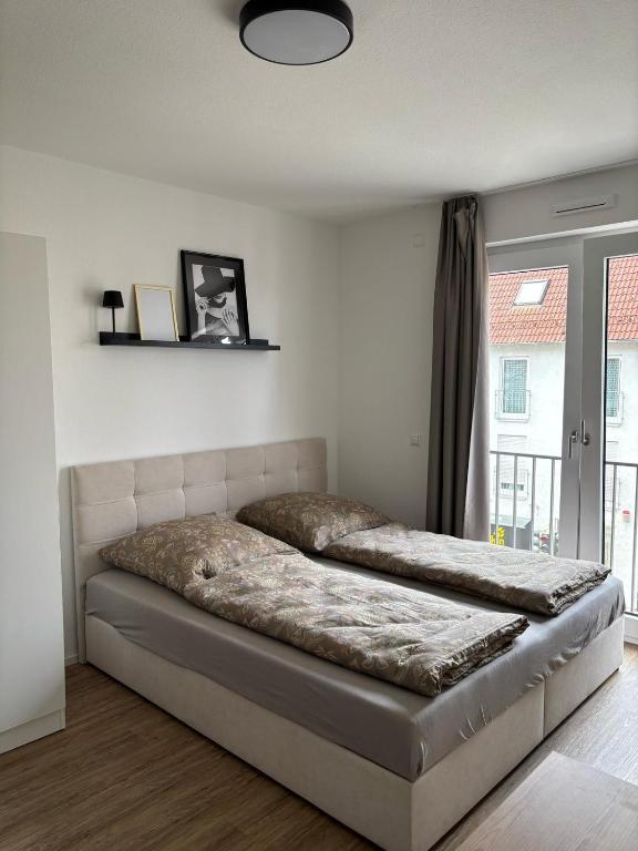 a bedroom with a bed in a room with a window at Queen Apartment in Metzingen