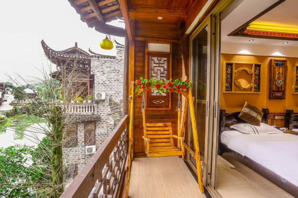 a room with a balcony with a bed and a staircase at Huaqianshu Theme Inn 高铁免费接站或送站一次 in Wang-ts'un