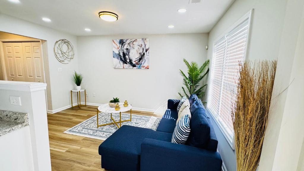 a living room with a blue couch and a table at Vacay escape, rooms in Charlotte in Charlotte