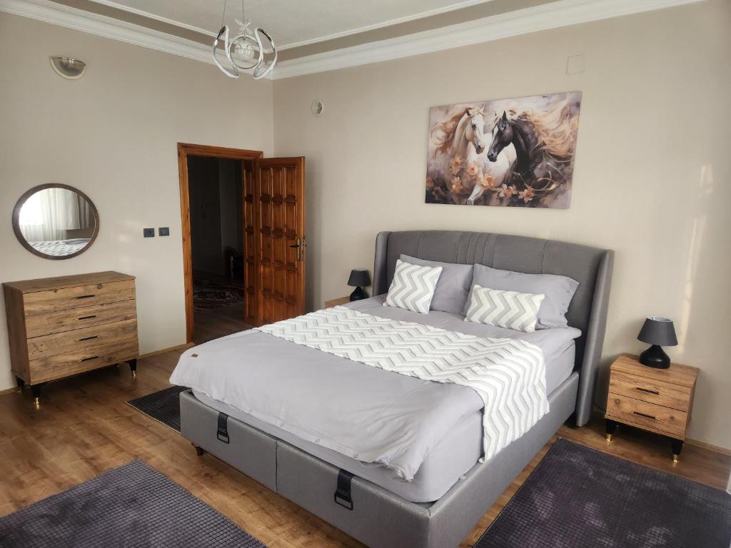 a bedroom with a bed and a painting on the wall at Cappadocia Essa Orange Stone House in Nevsehir