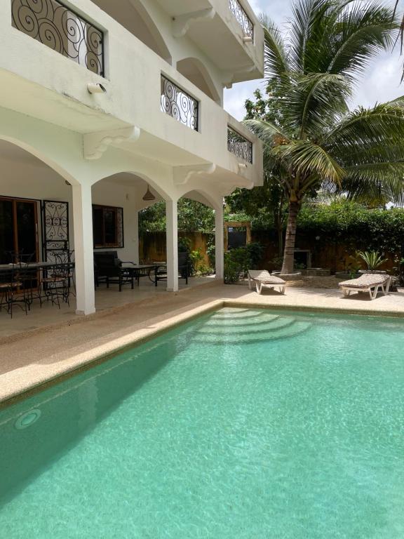 a swimming pool in front of a house at Villa Warang in Mbour