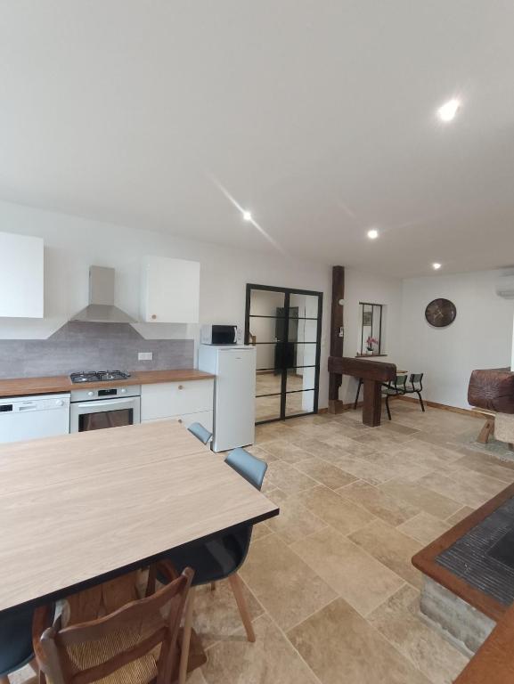 a kitchen and living room with a table and a table at Les Murmures Desbordes in Châteauvillain