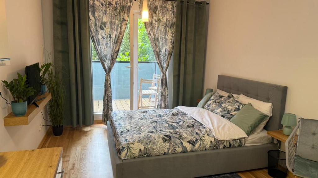 a bedroom with a bed and a large window at Green Leaf Studio in Wrocław