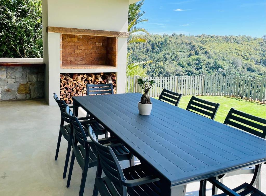 a blue table and chairs on a patio at Hilltop 39, Oubaai Golf Estate in Herolds Bay