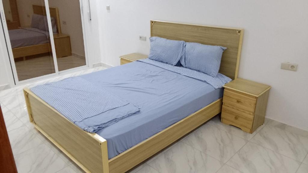 Monte ʼArrouitتجزئة الهناء العروي的一间卧室配有一张带蓝色床单和镜子的床