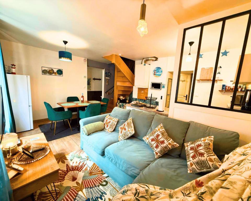 a living room with a blue couch and a kitchen at Giulia House Fécamp - Seaside Escape, Modern & Cozy in Fécamp