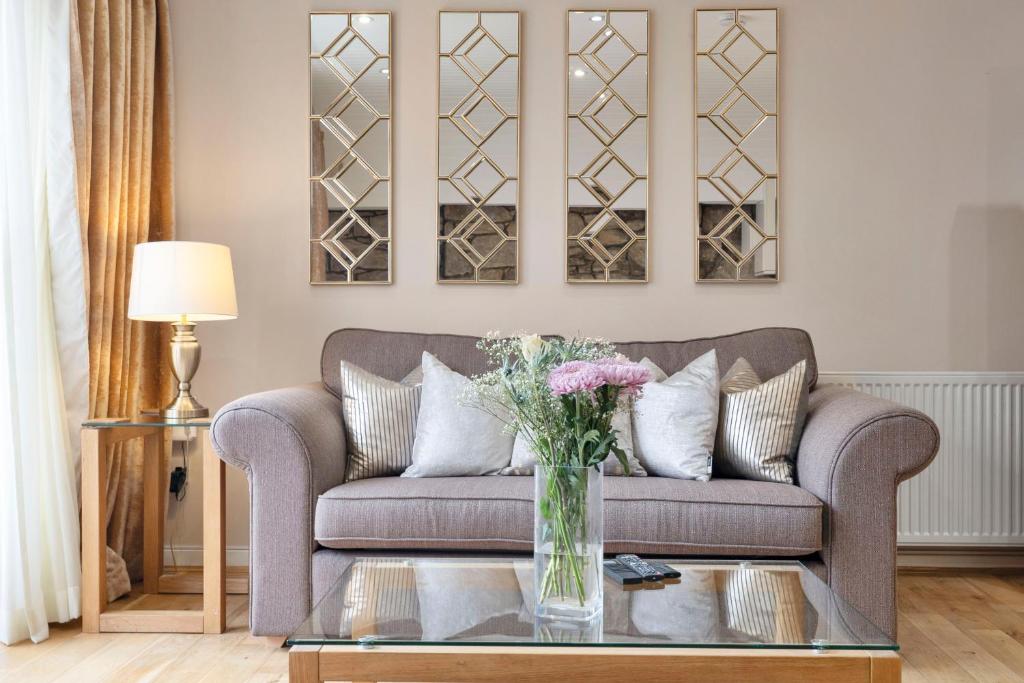 a living room with a couch and a vase of flowers at Rose Street flat in Edinburgh