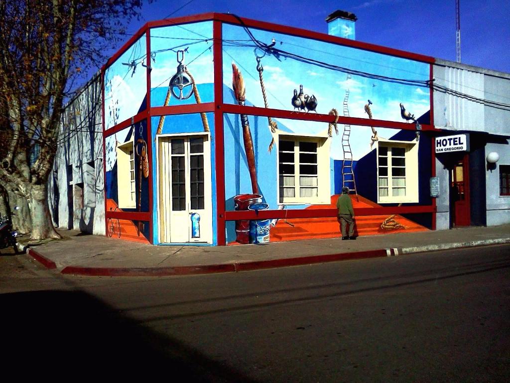 a man standing in front of a building on a street at Hostel San Gregorio in San Gregorio de Polanco