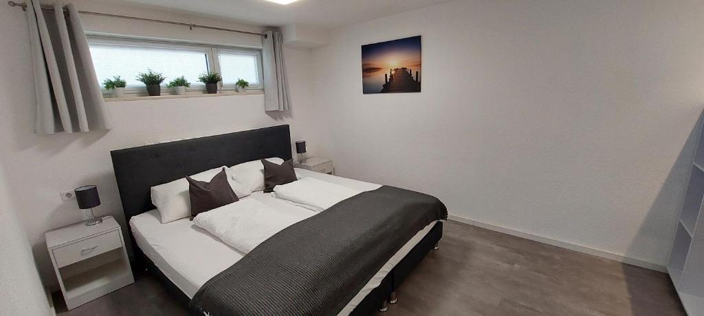 ein Schlafzimmer mit einem Bett mit weißen Kissen und einem Fenster in der Unterkunft FeWo Friedrichshafen in Friedrichshafen