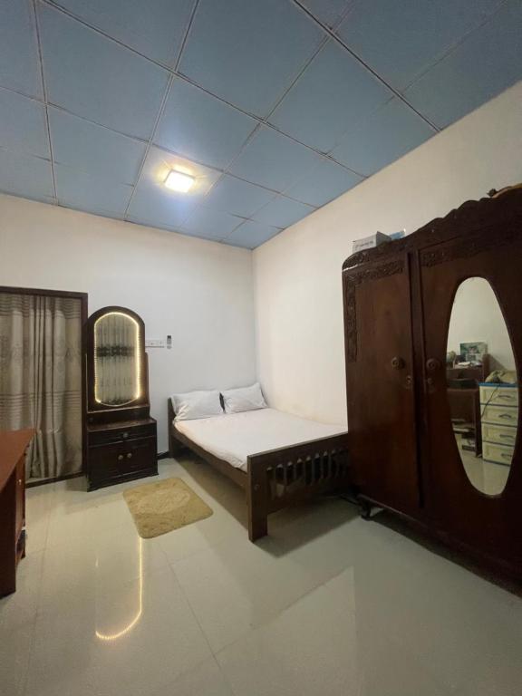 une chambre avec un lit, une commode et un miroir dans l'établissement Mount Lavender Weligama, à Weligama