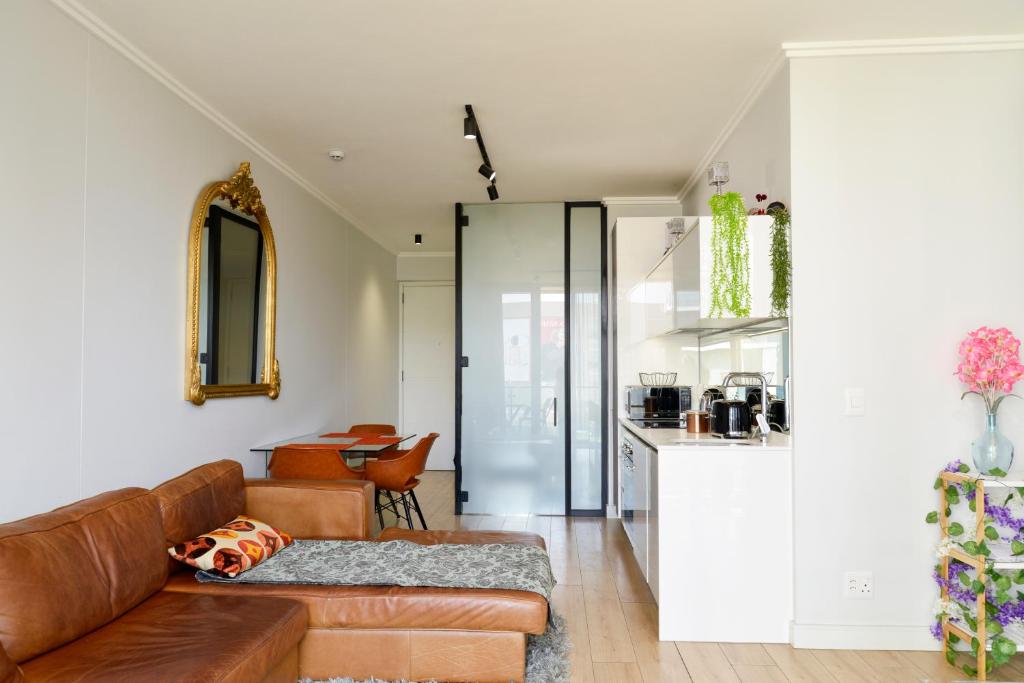 Una sala de estar con un sofá y una cocina. en Luxury Escape at Ellipse 1-Bed, Kitchen, Wi-Fi & Free Parking, en Midrand