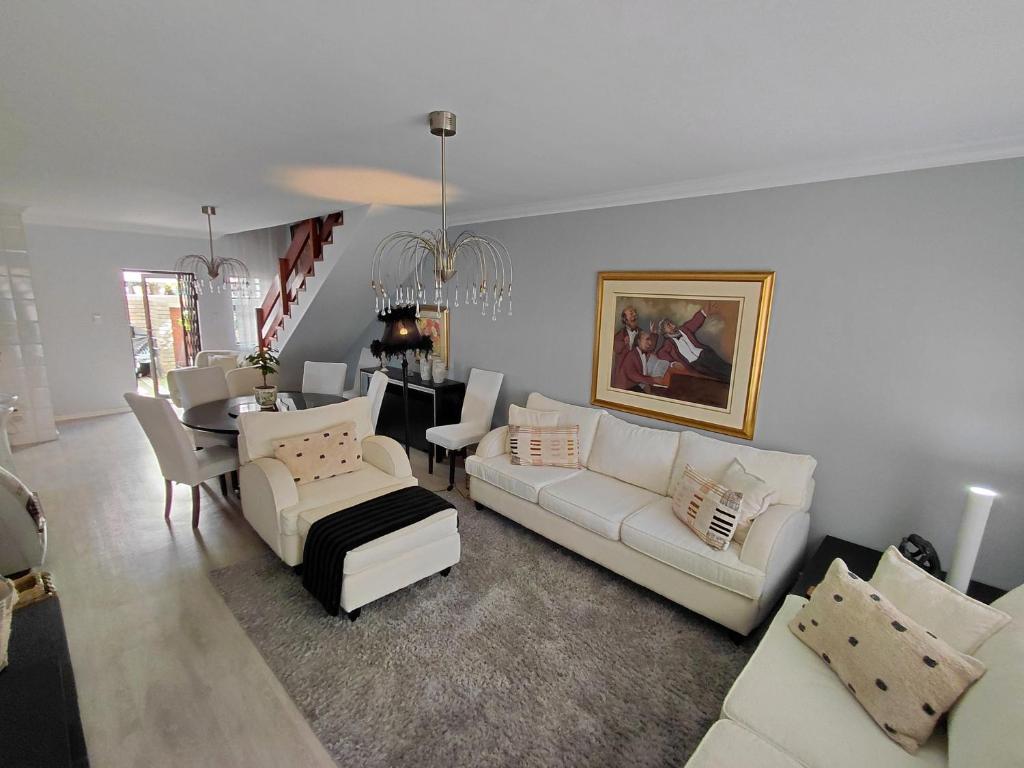 Una sala de estar con un sofá y un comedor. en Blouberg Beach Villa, en Ciudad del Cabo