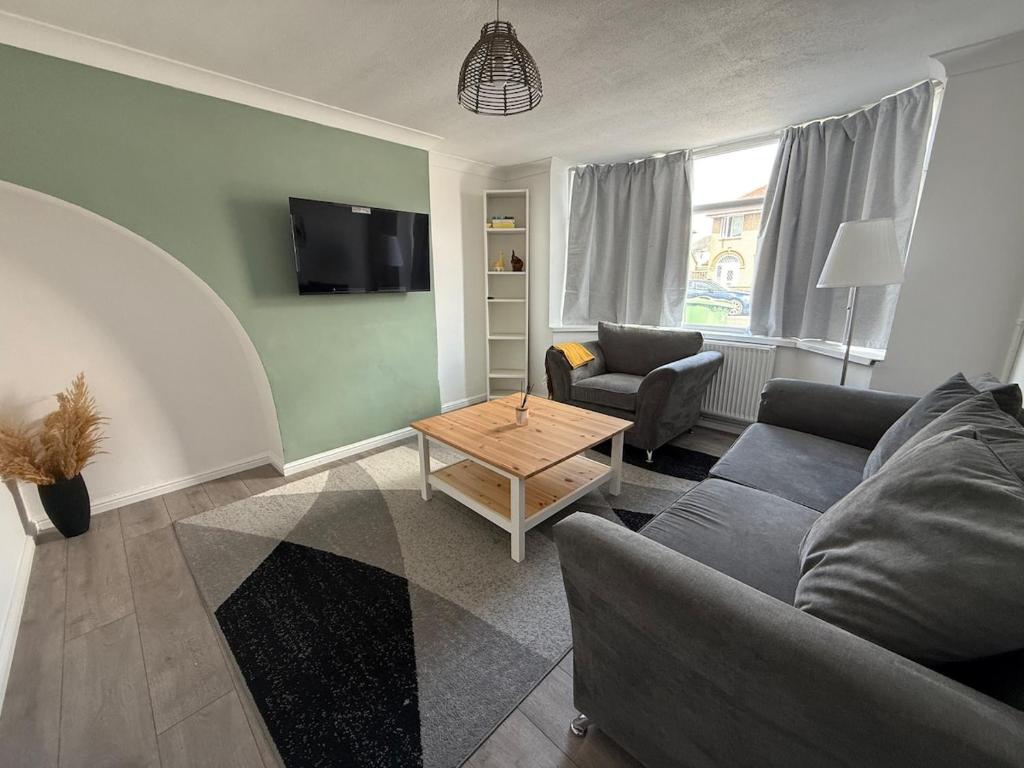 ein Wohnzimmer mit Sofa und Tisch in der Unterkunft Cosy 3 Bedroom Home, Parking & Bus in Oxford