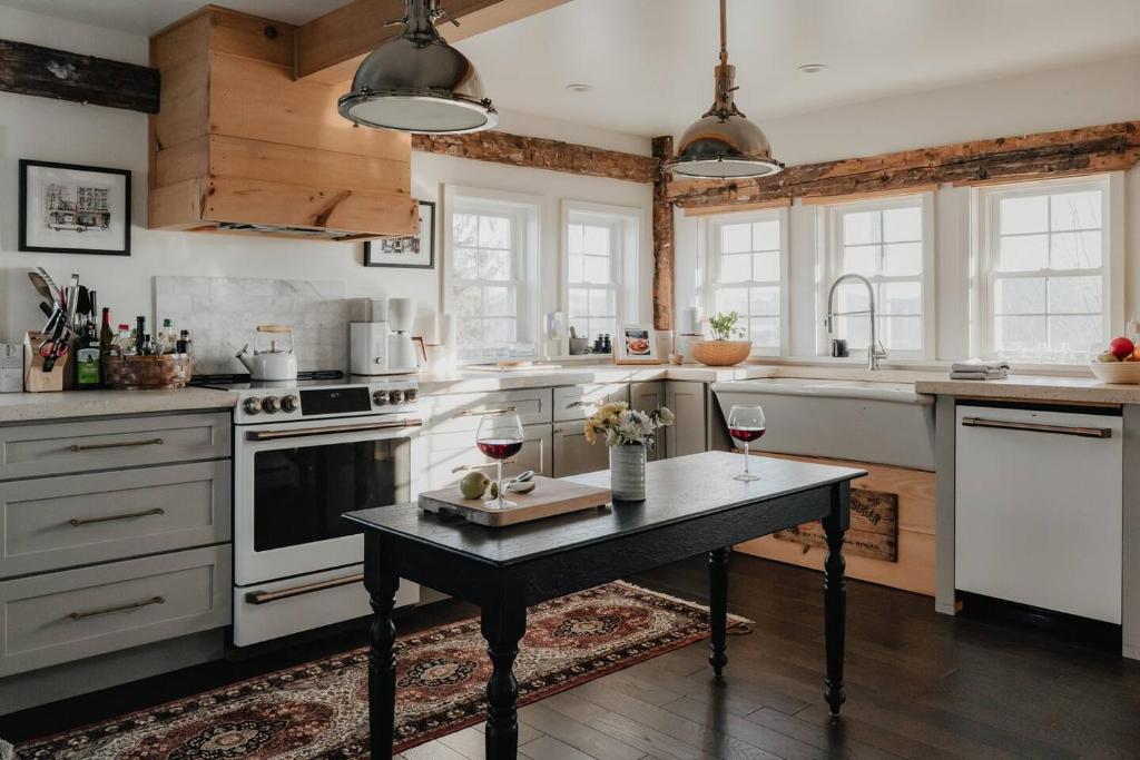 a kitchen with a table with two glasses of wine at Luxe Gabel Farmhouse Fire Pit & Country Views in Callicoon