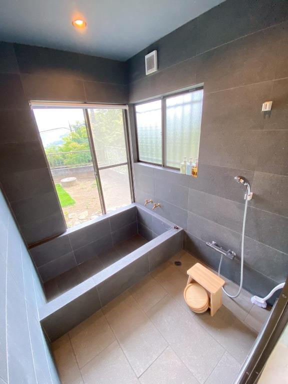 a bathroom with a tub and a toilet and a shower at Boogie Garden in Yugawara