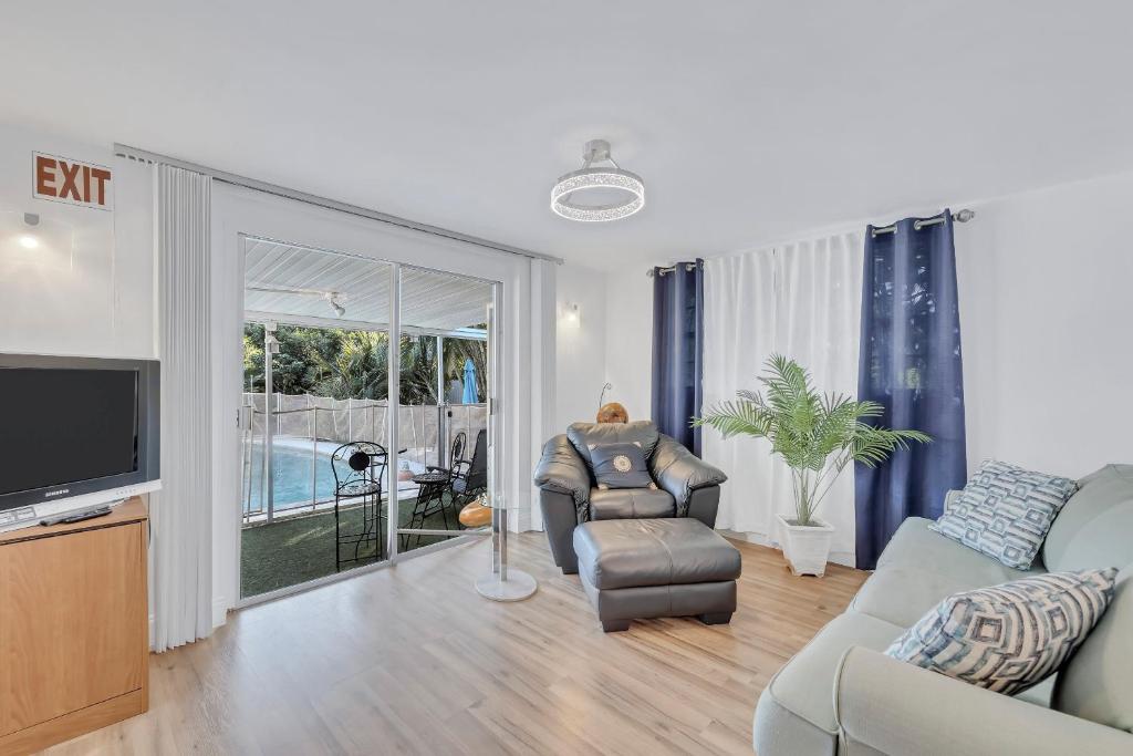 Una sala de estar con un sofá y un televisor. en Tranquil Pool Home in Hollywood Close to Beach Airport, en Hollywood