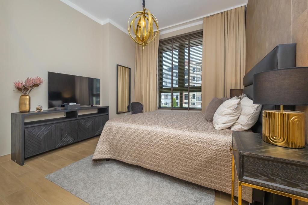a bedroom with a large bed and a television at Port de la Mer Luxury Sleeps 4Person in Dubai
