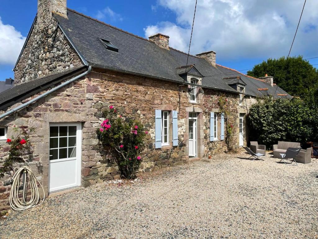an old stone house with a white door at Maison de charme, jardin, 5km plage, côte d'Emeraude in Plévenon