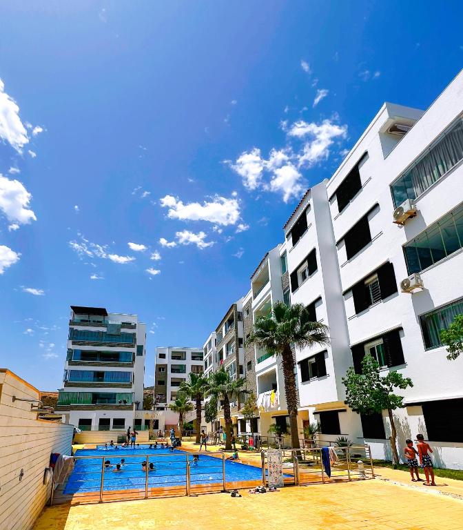 a large swimming pool in a city with buildings at Visit Chamal - Raihana in Oued Laou