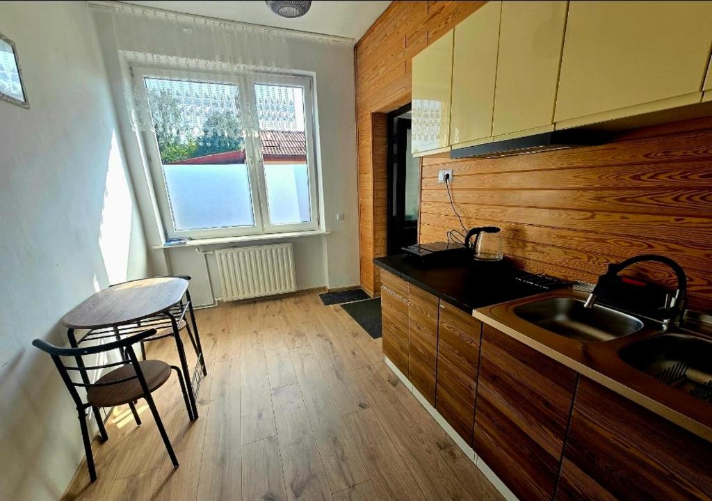 a kitchen with a sink and a table and chairs at Perłowy in Biłgoraj