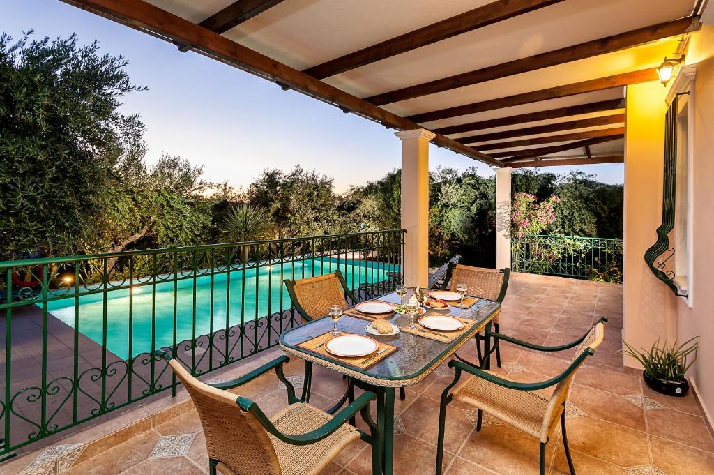 a patio with a table and chairs next to a swimming pool at Villa Vallia - Villa Marina in Kato Galatas