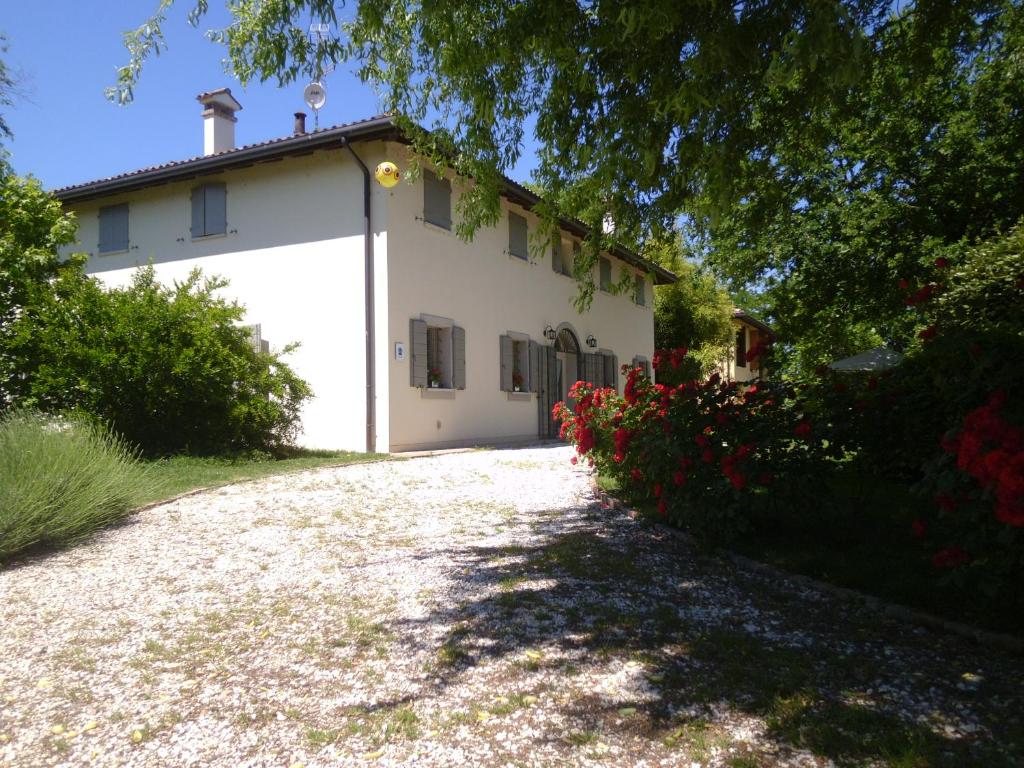 una casa bianca con un albero e un vialetto di ghiaia di Locanda del Toro a Calderara di Reno