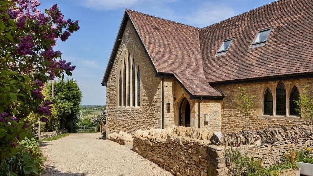an old brick church with a stone wall at Luxury Cotswolds Retreat nr Estelle Manor 
