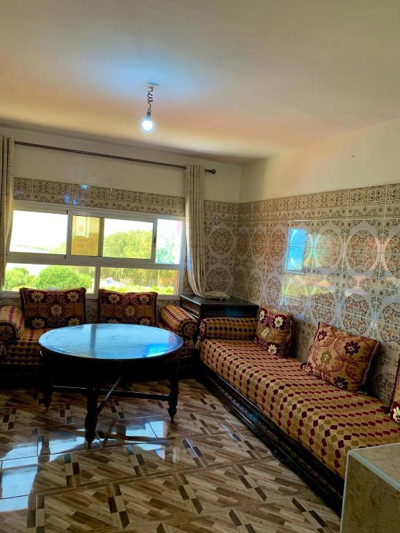 una sala de estar con un sofá y una mesa en El'baraka House, en Oualidia