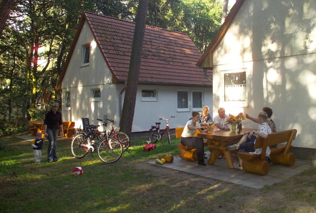 Un groupe de personnes assises autour d'une table dans une cour dans l'établissement Ferienpark Retgendorf, à Retgendorf